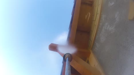 Wood-overhang-of-house-being-cleaned-with-high-pressure-washer,-neat-maintenance,-POV