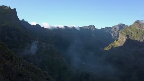 Madeira,-Portugal---Atemberaubende-Landschaft-Der-Schroffen-Bergkette-Mit-Nebel-Unter-Dem-Blauen-Himmel-An-Einem-Sonnigen-Tag---Luftdrohnenaufnahme