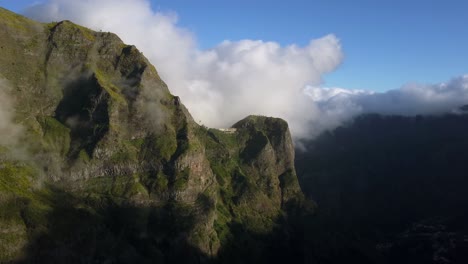 Madeira,-Portugal---White-Cottony-Clouds-At-The-Peak-Of-Rugged-Mountain-Range-Under-The-Blue-Sky-On-A-Sunny-Weather---Aerial-Drone-Shot