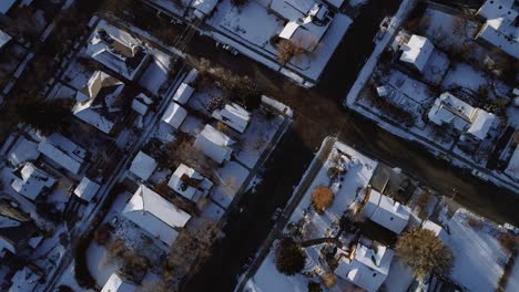 An-early-morning-drone-shot,-birds-eye-view-of-snowy-neighborhood-in-the-winter