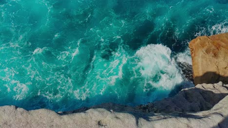 Static-birds-eye-view-of-waves-breaking-against-a-cliff-on-the-Sydney-coastline
