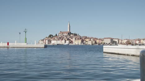 Beautiful-wide-shot-of-Rovinj-Island-with-old-builduings-and-church-during-blue-sky-and-calm-water