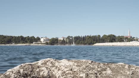 Low-angle-wide-shot-of-showing-sea-and-coastline-of-Rovinj-during-blue-sky-and-sunny-day-in-Croatia
