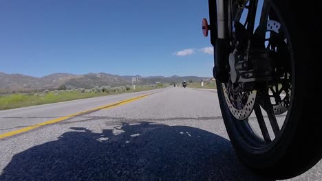 Riding-motorbike-on-open-road,-slow-motion-front-wheel-perspective