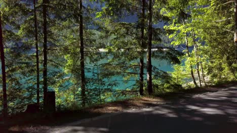 Driving-along-the-forested,-emerald-green-shores-of-Klöntalersee,-Glarus,-Switzerland