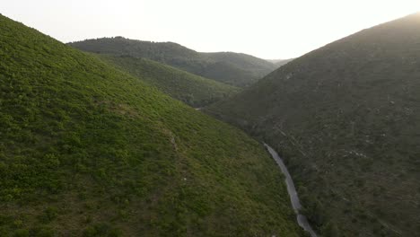 Vuelo-Sobre-Un-Camino-Sinuoso-Entre-Las-Montañas-En-El-Valle-Verde-En-La-Isla-Griega-De-Zakynthos