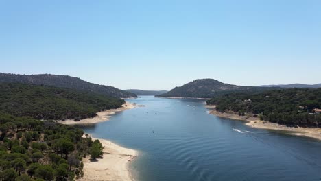 Aerial-view-of-beautiful-natural-lake-landscape-in-San-Juan-reservoir,-Madrid-on-a-sunny-day