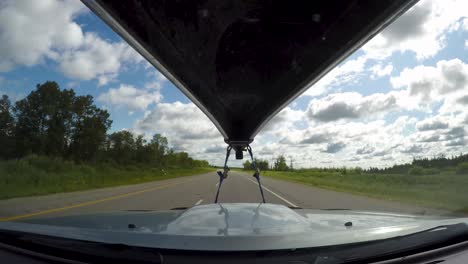 Fahrzeit-Verfällt-Auf-Der-Autobahn-Durch-Waldgebiet-Mit-Kanu-Auf-Dem-Dach-Eines-Lastwagens-In-Manitoba,-Kanada