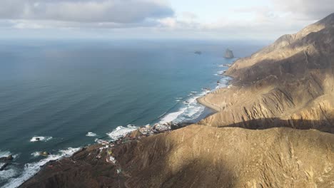 Aerial-view-of-coastal-cliffs-and-waves-crashing-against-the-shore-in-Tenerife,-Canary-Islands