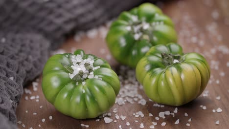 Video-of-green-tomatoes-kept-on-a-wooden-surface-for-food-photography