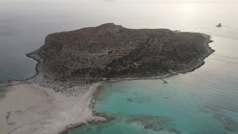 Aerial-walkthrough-towards-the-picturesque-island-of-Gramvousa-before-sunset-in-Crete-island,-Greece