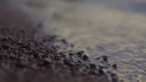 Extreme-Closeup-Of-Rolling-Waves-Onto-Pebbled-Shoreline-At-Summer