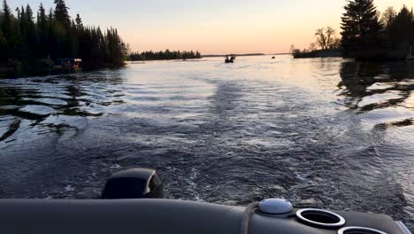 Boating-on-Lac-Du-Bonnet-at-dusk-looking-backwards-from-pontoon-boat-Manitoba-Canada