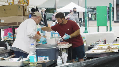 Two-men-prepare-and-serve-food-during-Dogwood-Festival,-Siloam-Springs,-Arkansas