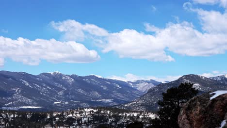 Meist-Blauer-Himmel-Und-Wolken-Im-Zeitraffer-Während-Des-Frühlings,-Der-Die-Verlorene-Bachwildnis-Mit-Schnee-Auf-Den-Gipfeln-Und-In-Den-Bäumen-In-Den-Felsbergen,-Colorado,-Usa,-Betrachtet