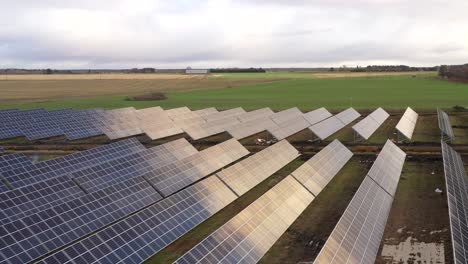 fast-drone-shot-flying-and-circling-over-solar-power-plant,-panels-are-chaining-color