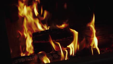 Burning-wood-in-fireplace-moved-by-iron-poker
