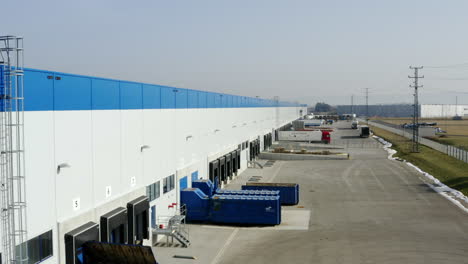 Rising-Aerial-Shot-Of-Trucks-Loading-At-A-Industrial-Shipping-Distribution-Depot