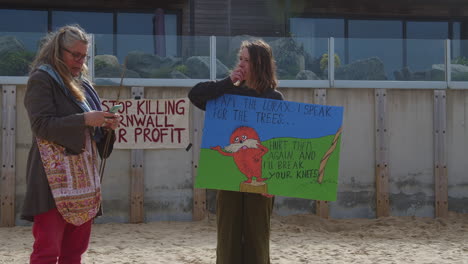 Zwei-Weibliche-Demonstranten-Reden-Und-Lachen,-Während-Sie-Am-Strand-Vor-Dem-Carbis-Bay-Hotel-In-St