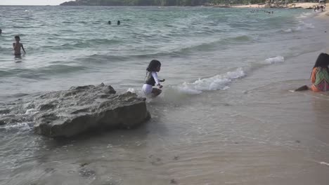 Filmaufnahme-Eines-Kindes,-Das-An-Einem-Strand-Auf-Einen-Felsen-Springt