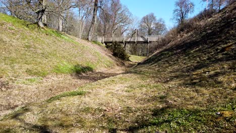 Grafsnas-Castle-moat-and-bridge-on-a-sunny-day-in-Sweden,-wide-shot-pan-left
