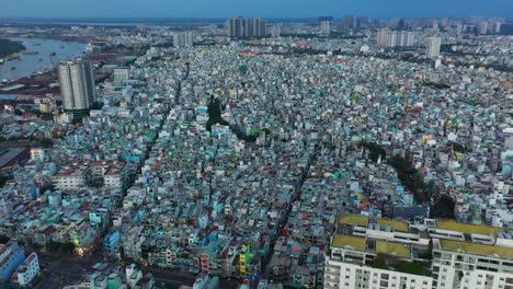 wide-drone-fly-in-over-densely-populated-area-and-port-of-Saigon,-or-Ho-Chi-Minh-City,-Vietnam-with-thousands-of-small-terrace-houses-and-a-maze-of-roads-and-alleyways