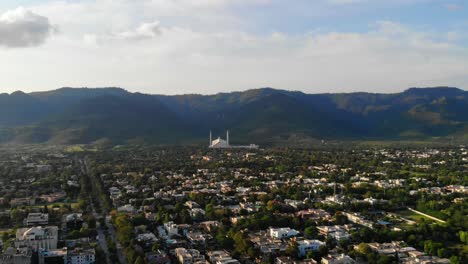 Aerial-View-Across-Islamabad-Cityscape-With-Faisal-Masjid-Reveal-At-Foothill-Of-Margalla-Hills