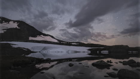 Lapso-De-Tiempo-De-Movimiento-De-La-Vía-Láctea-Sobre-El-Lago-Glacial-En-El-Parque-Nacional-De-Jotunheimen,-Noruega