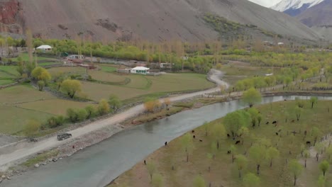 Antena-Sobre-Todoterreno-A-Lo-Largo-De-Caminos-Rurales-Al-Lado-Del-Río-En-El-Distrito-Del-Valle-De-Ghizer-En-Pakistán