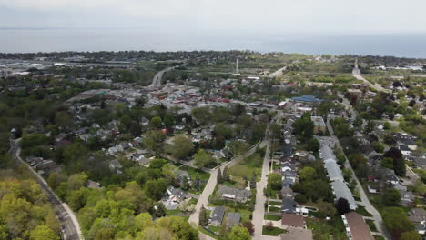 Aerial-backwards-flight-showing-rural-suburb-area-of-Hamilton-District-with-Lake-Ontario-in-backdrop