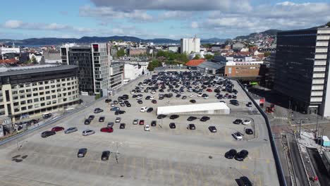 Estacionamiento-Bygarasjen-En-La-Azotea-En-El-Centro-De-La-Ciudad-De-Bergen-Durante-El-Brillante-Día-De-Verano---Antena-Ascendente-Con-Inclinación-Hacia-Abajo-Y-Tren-Ligero-Que-Pasa-Por-Debajo---Noruega