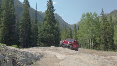 Red-Jeep-trail-riding-on-a-rocky-rock-portion-of-Poughkeepsie-Gulch-Trail-through-the-San-Juan-Mountains