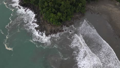 Wide-top-down-aerial-view-of-a-beach-in-Costa-Rica-with-rocks-and-trees