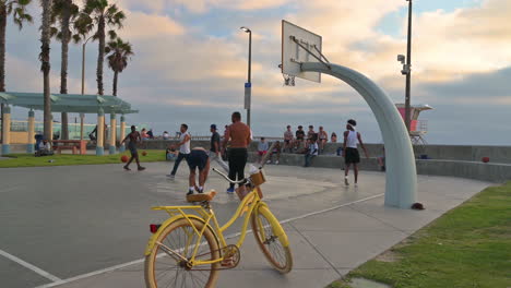 Static-shot-of-guys-playing-hoops,-yellow-bike-in-foreground