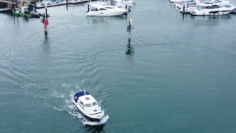 Kleines-Segelboot,-Das-Den-Luxusyachthafen-Verlässt,-Der-Zum-Ozeanwasser-Aus-Der-Vogelperspektive-Fährt