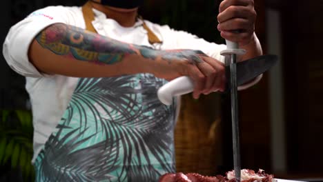 Lateinischer-Koch,-Der-Messer-Schärft,-Bevor-Oktopus-Meeresfrüchte-Mexikanischer-Restauranturlaub-Geschnitten-Wird