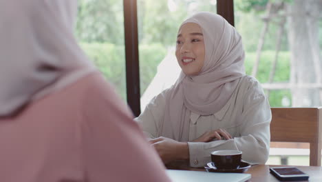 Upwardly-mobile-Asian-Muslim-business-entrepreneur-SME-start-up-group-of-young-man-and-women,-discussing-sale-and-marketing-analysis,-Asian-Muslim-SME-teamwork-e-commerce-concept