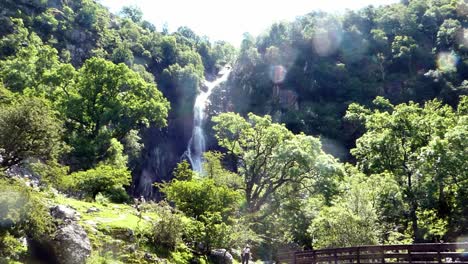 Aber-falls-people-hiking-in-Snowdonia-mountain-valley-Welsh-national-park-waterfall