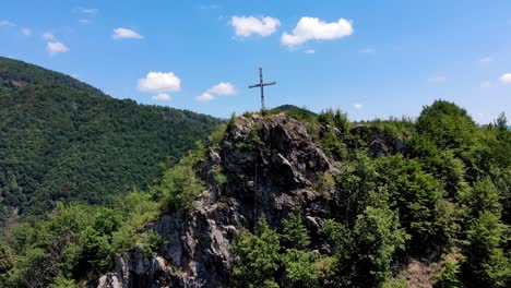 Big-Cross-In-Top-Of-A-Mountain-In-Romania-On-A-Sunny-Day---Aerial-shot