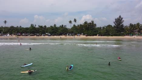 Tiro-Fijo-De-Gente-Surfeando-En-La-Deslumbrante-Playa-De-Arena-Tropical-De-Mirissa,-Sri-Lanka