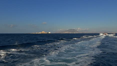 Fast-motorboat-navigate-towards-Isola-di-Formica-island-in-Sicily-leaving-long-wake-on-sea-surface