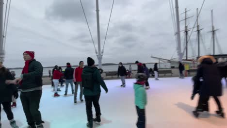Skating-on-ice-in-Toronto-Harbourfront-skating-rink-during-winter---January-2022---Skating-in-urban-city-during-winter-in-Ontario,-Canada-on-new-years-near-waterfront