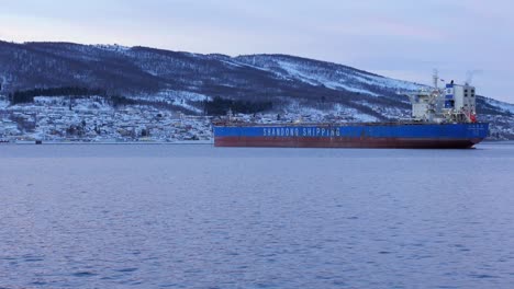 Panning-across-huge-transportation-ship-during-cold-polar-night-above-the-arctic-circle-in-Narvik,-northern-Norway