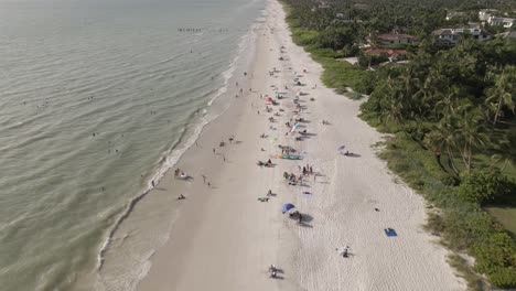 People-enjoy-white-sandy-ocean-beach-on-sunny-warm-Florida-gulf-coast