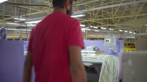 Indischer-Männlicher-Arbeiter-Mit-Gesichtsmaske-In-Der-Nähfabrik,-Die-Textil-Während-Der-Covid-19-pandemie-In-Indien-überprüft