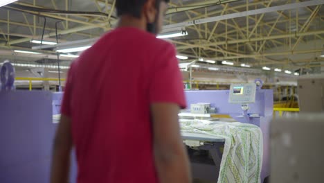 Trabajador-Masculino-Indio-Con-Máscara-Facial-En-La-Fábrica-De-Costura-Revisando-Textiles-Durante-La-Pandemia-De-Covid-19-En-India