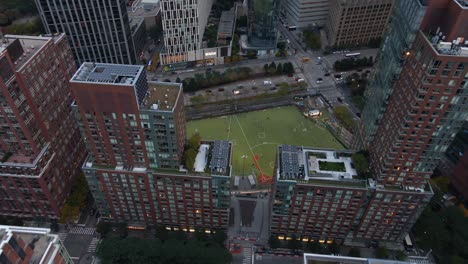 Vista-Aérea-Con-Vistas-A-Un-Campo-De-Juego,-Revelando-Rascacielos,-En-Tribeca,-Nueva-York---Inclinación,-Disparo-De-Drone