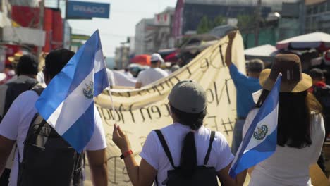 Salvadoran-walks-with-national-flags-during-a-peaceful-protest-in-the-city-streets-against-current-president-Nayib-Bukele---slow-motion