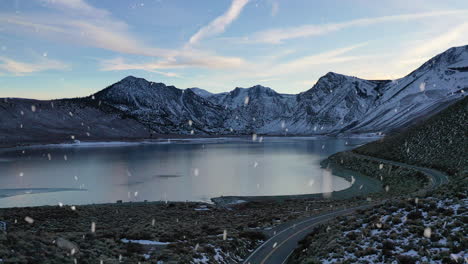 Hermoso-Camino-De-Montaña-Con-Revelación-Del-Lago-Durante-La-Temporada-De-Invierno-Y-Nevadas,-Vista-Aérea-Ascendente