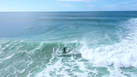 4K-Drohnennahaufnahme-Eines-Professionellen-Surfers,-Der-Eine-Wunderschöne-Blaue-Ozeanwelle-In-Australien-Schnitzt